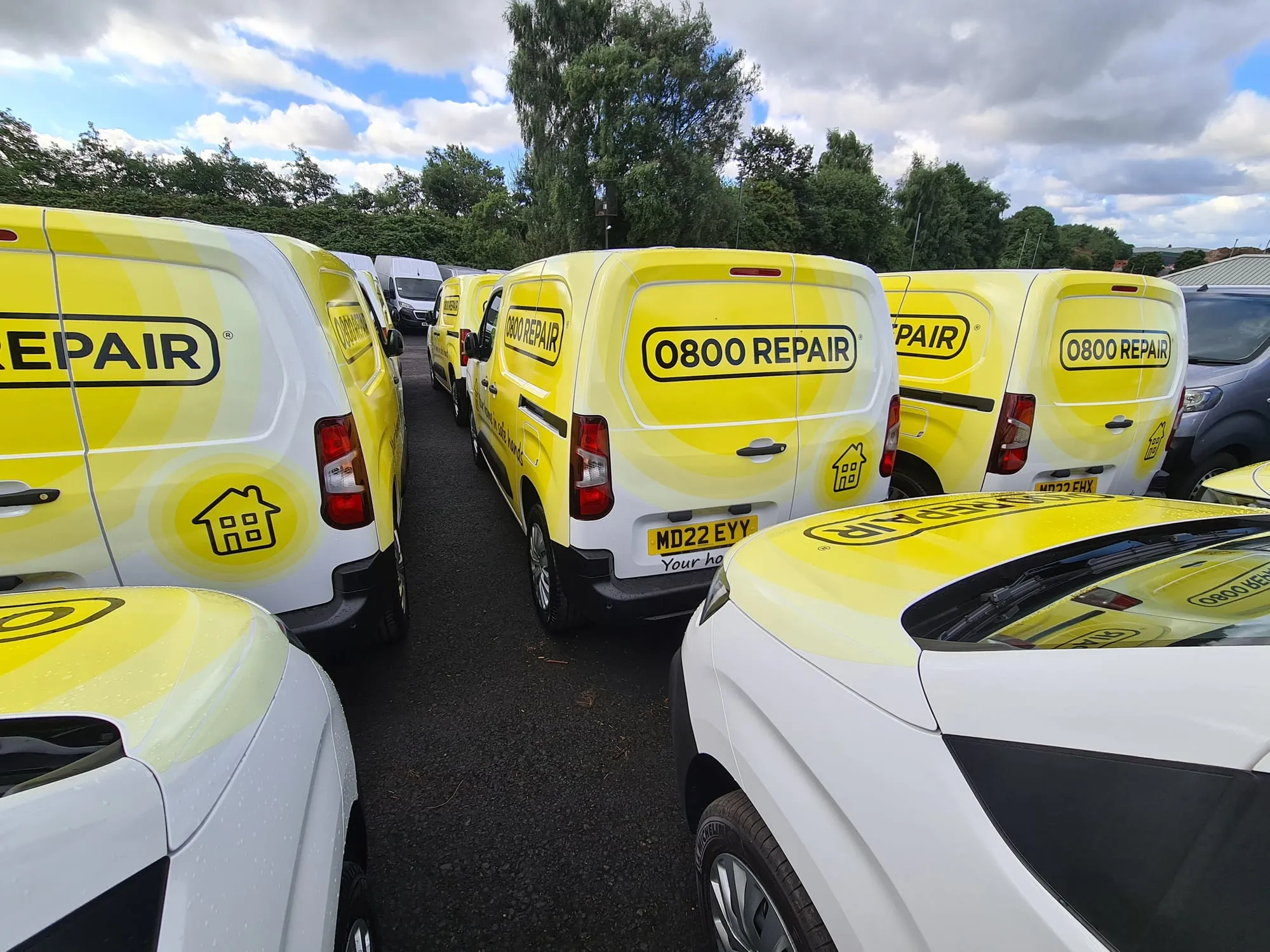 Group of vans with matching yellow 0800 REPAIR branding