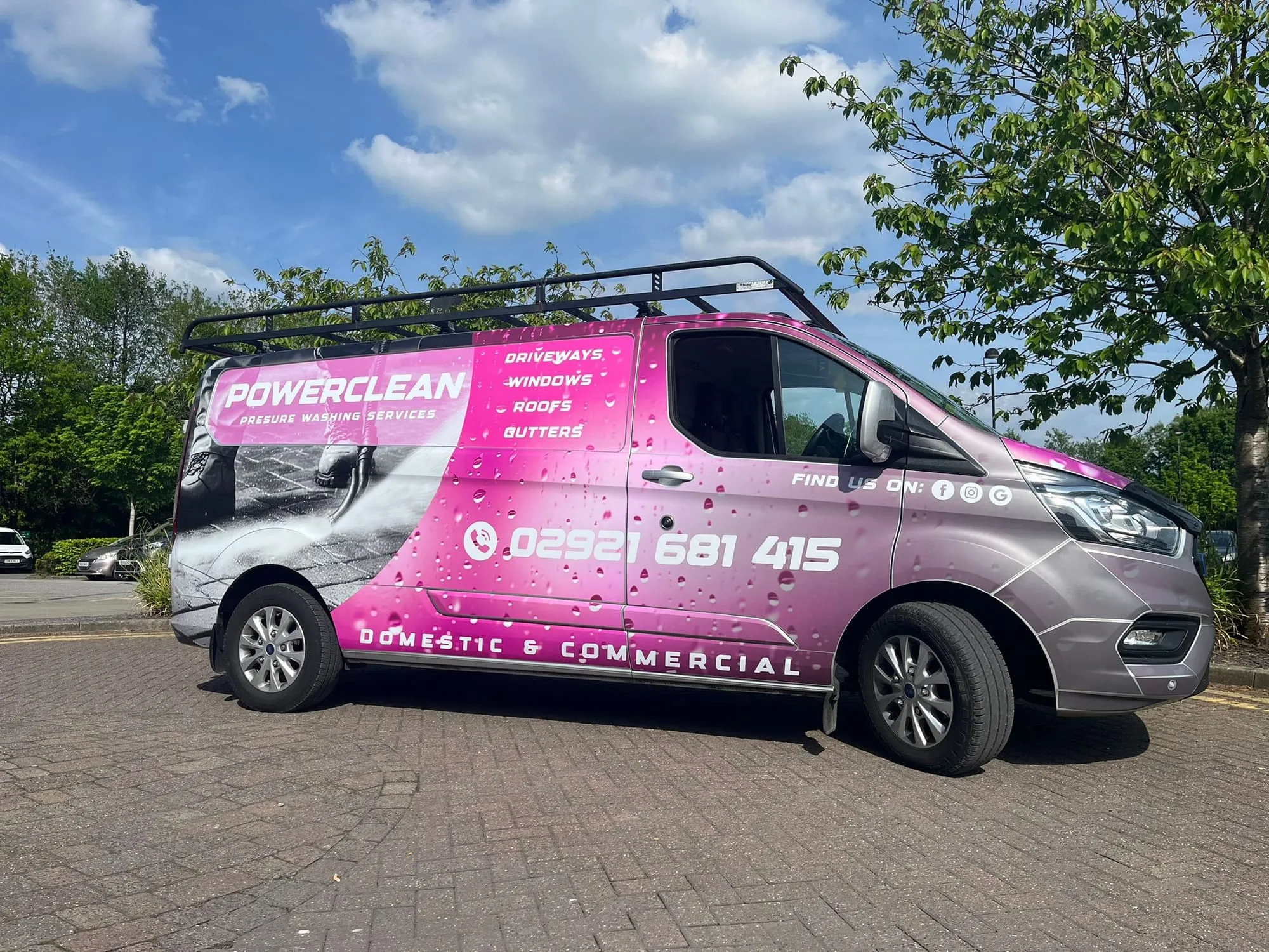 Van with a full pink and grey wrap carrying the business name, services and phone number