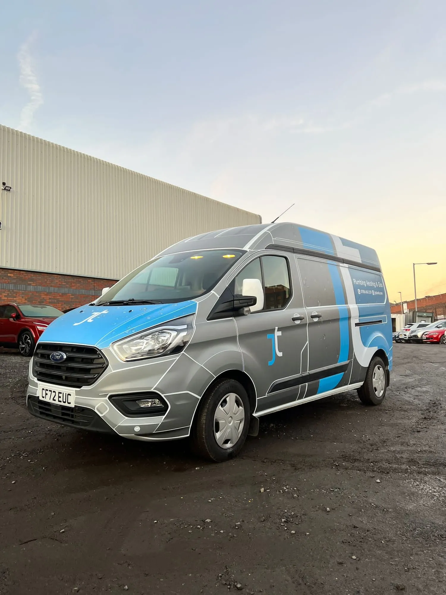 Silver high-roof van with blue and dark graphics on the side