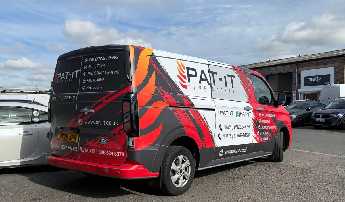 Rear and side of the PAT-IT van showing the wrap and contact details