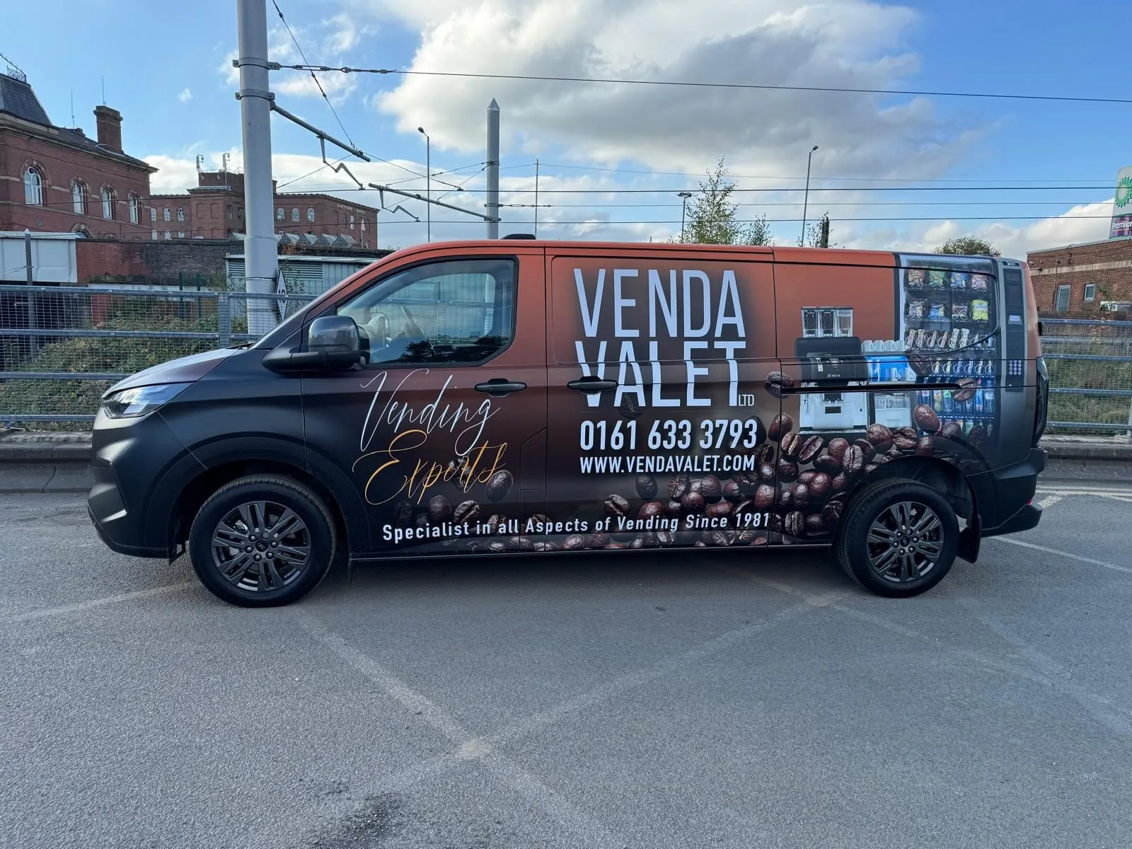 Van with a dark red and black wrap carrying the business name and phone number